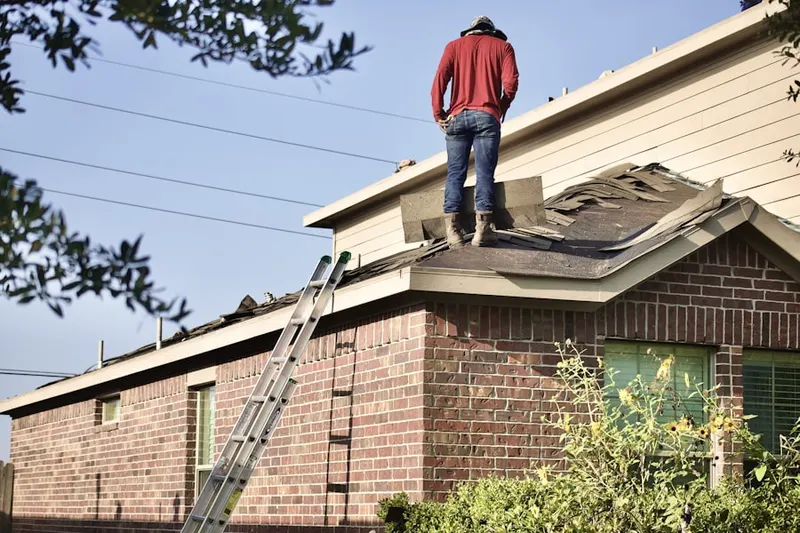 Professional roofer working on a residential roof in Farm Street Station